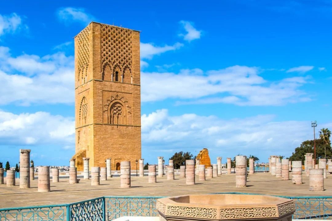 The Hassan Tower above the columns of its unfinished mosque, a zellij fountain in the foreground, Rabat